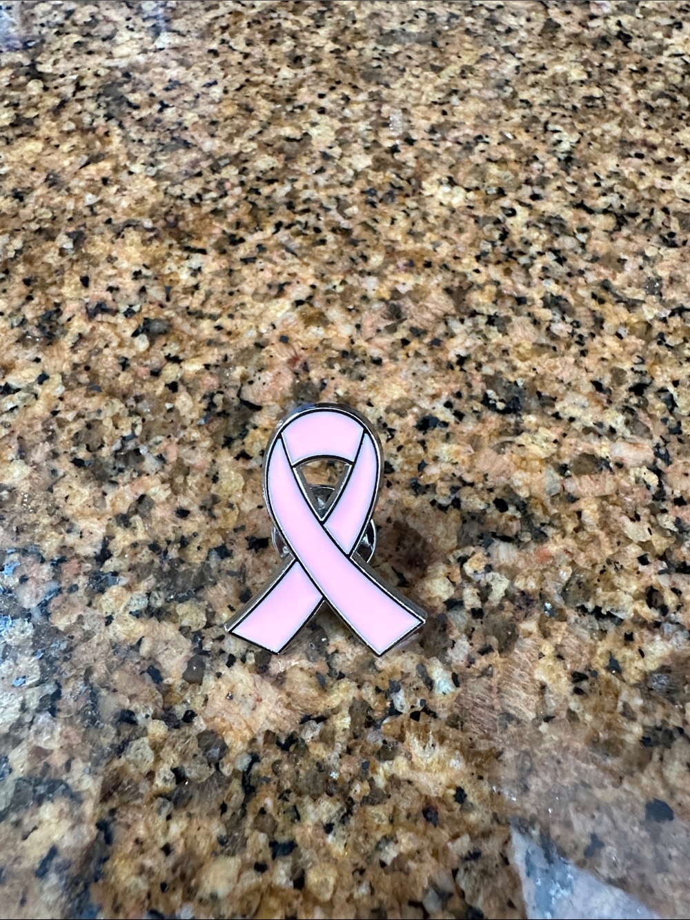 Susan G Komen breast cancer awareness pin.